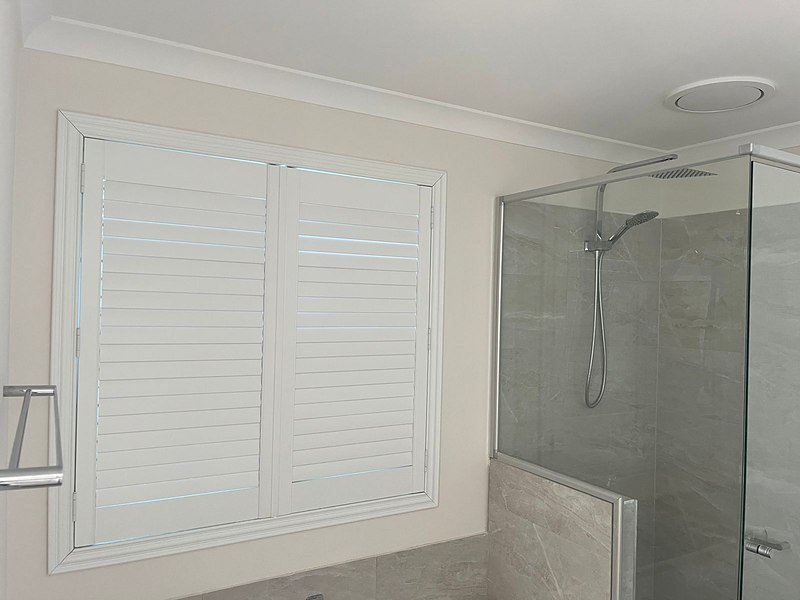 White plantation shutters filtering soft daylight