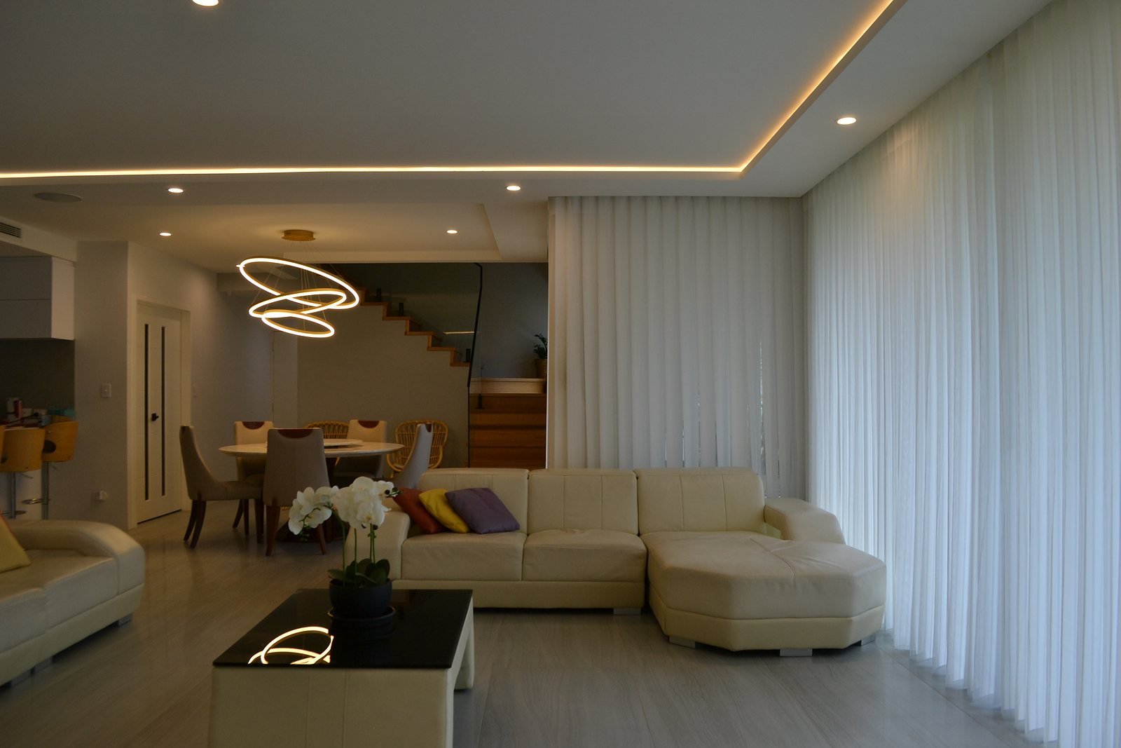 Floor-to-ceiling sheer curtains glowing in an elegant Perth living room at dusk